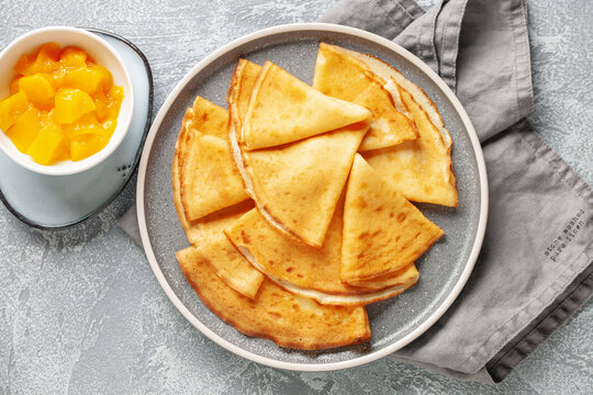 Crepes (Russian Blini) on grey background,. Homemade thin fresh crepes for breakfast or dessert. Top view