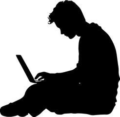 Silhouette of a young man sitting and working on a laptop computer