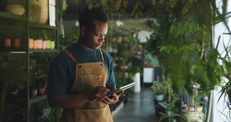 Black man, tablet and reading in nursery with checklist, inventory management or supplier order....