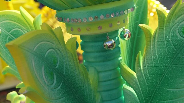 A green and yellow kavadi in close up.