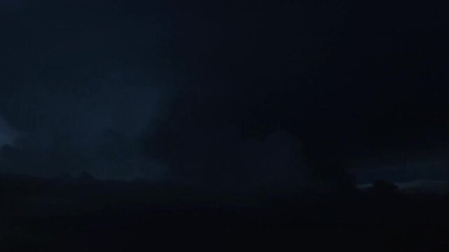 nighttime cinematic storm clouds thick dark formations drifting slowly lightning illuminating cloud mass from within dramatic realistic atmospheric light deep blue gray tones strong contrast moody pow