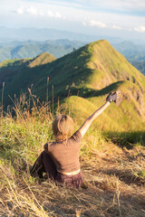 Hiker with backpack reaches the summit of mountain peak. Success, freedom and happiness, achievement in mountains.