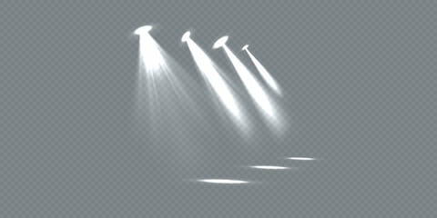 Four bright spotlights shine on a dark stage. Spotlights create dramatic lighting. Each spotlight casts a focused beam. Spotlights illuminate the stage.