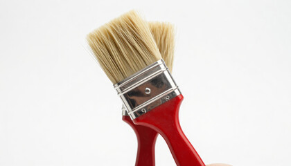 Two red-handled paint brushes with beige bristles, isolated on a white background