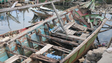Fishing boats made of wood are damaged and not repaired, plus there is a scattering of plastic waste around the estuary. Beaches like this make the environment smelly and the fish become unhealthy