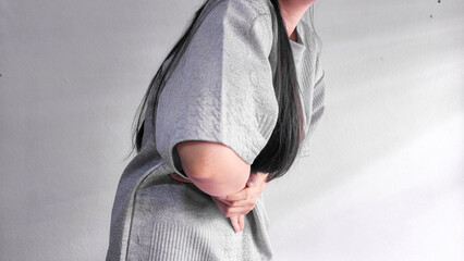 Woman holding stomach in pain, abdominal pain and stomach ache concept