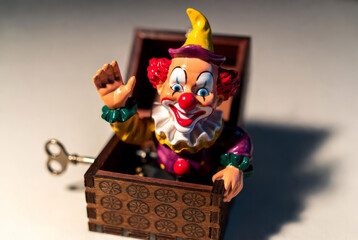The box suddenly opens and a clown figure suddenly jumps out of it, frightening everyone around.