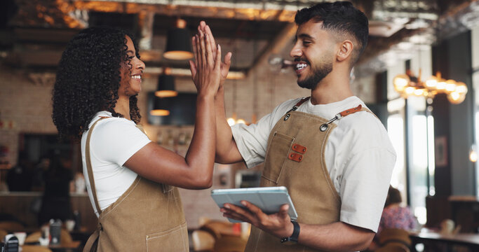 Waiter, high five and people with tablet in coffee shop for barista training, counting stock or inventory management. Hospitality industry, excited and digital tech for cafe system or order success - Powered by Adobe