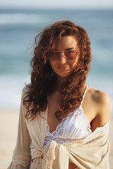 Stylish Woman in Lace Top and Sunglasses Enjoying a Sunset Beach Walk