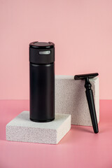 Black cosmetic product or sunscreen cosmetic with stylish props on pink background.