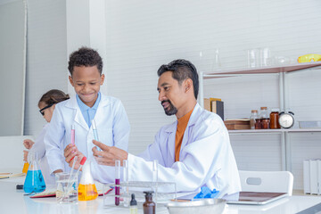 Group of multicultural African boy and elementary students girl kids friend wearing lab coat uniforms using microscope with teacher in laboratory room, lifestyle learning education in science class