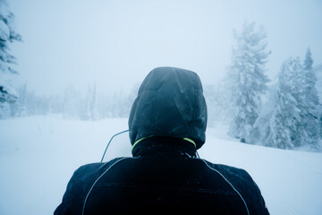 A man rides a snowmobile through the taiga