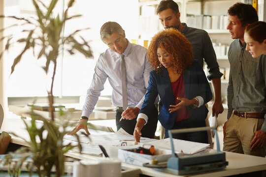 Meeting, team and architecture with business people in office for floor plan, discussion or feedback. Property developer, collaboration and real estate contractor with employees in agency for project