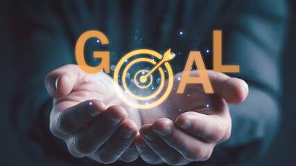 Business hands presenting glowing target with arrow symbol representing goal achievement, success strategy, and business objectives.