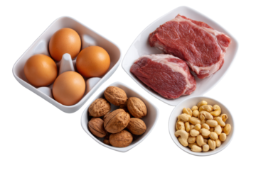 Raw red beef steaks eggs walnuts and cashew nuts arranged in white bowls on black meat protein