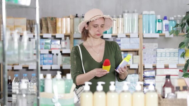 Woman are busy choosing insect repellent spray at pharmacy, compare price and manufacturer brand. Client finds out expired date information