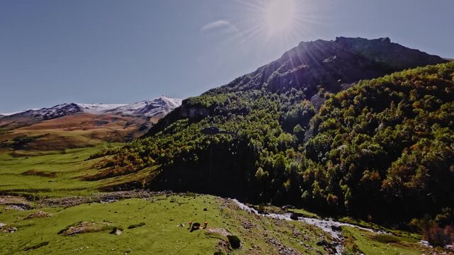 An aerial view from a quadcopter FPV drone of a civilian helicopter transporting cargo high in the mountains. Slingers tie cargo to the helicopter.