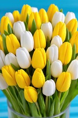 Bunch of yellow and white tulips in a glass vase, spring season