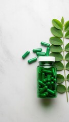 Green herbal capsules in a bottle with fresh plant leaves, natural health concept