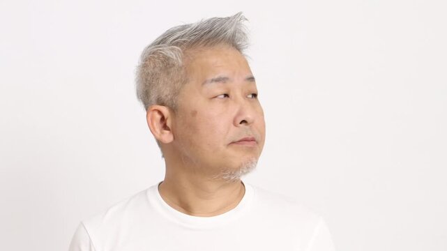 4K video of a middle-aged gray-haired man moving face to the right and the left on white background