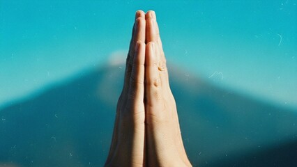Close Up of Human Hands Pressed Together in Prayer or Namaste Gesture on Blue Background