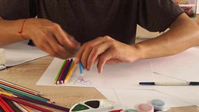 a guy draws with pencils