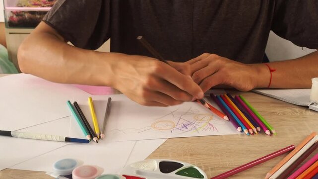 a guy draws with pencils