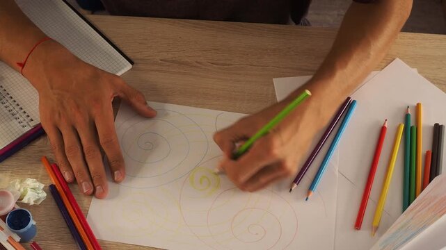 a guy draws with pencils