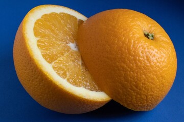 Halved fresh orange on a vibrant blue background.