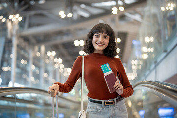 Asian young woman passenger walk in airport terminal to boarding gate.