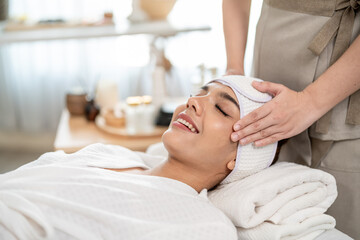 Beautiful woman getting head and facial massage treatment at beauty spa