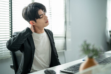 Exhausted Asian young businessman worker working on table in office.