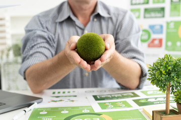 A diverse business team analyzing environmental charts and graphs in a collaborative meeting to create sustainable strategies in a modern office.