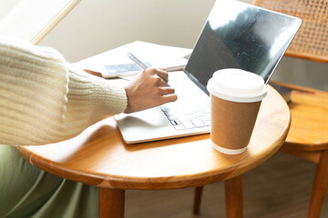 Young Asian woman enjoying a peaceful moment reading a book near window. Calm lifestyle, self-learning, and mindfulness at home.