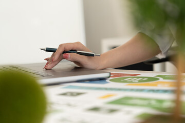 A diverse business team analyzing environmental charts and graphs in a collaborative meeting to create sustainable strategies in a modern office.
