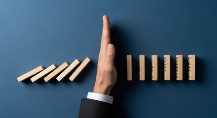 Risk Management and Prevention Concept with Hand Stopping Falling Wooden Dominoes