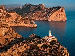 Mallorca, Spain - Aerial view of the Lighthouse at Cap de Formentor at sunrise with amazing cliffs and clouds and blue sky at background © zgphotography