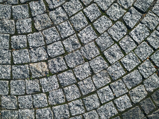 A close-up of gray granite pavers laid in a semicircular arc. A concept for a durable natural stone flooring solution.