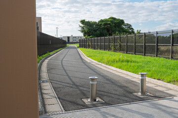 水道施設内の舗装された管理用道路と上下可動式の金属製車止めポール