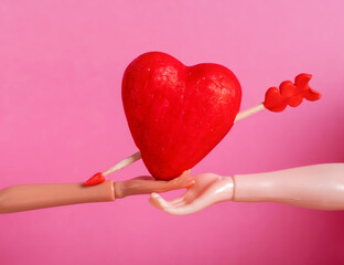 Mannequin Hands Holding Red Heart with Arrow on Pink Background