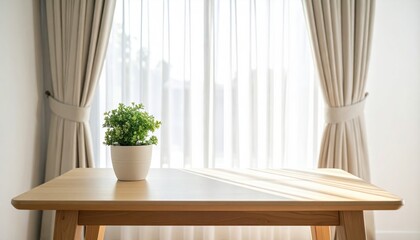 A minimalist interior featuring a wooden table, potted plant, and sunlight streaming through sheer curtains.