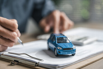 Car purchase concept with contract signing, showing vehicle agreement, insurance coverage, auto loan planning, and financial responsibility during dealership buying and ownership transfer.