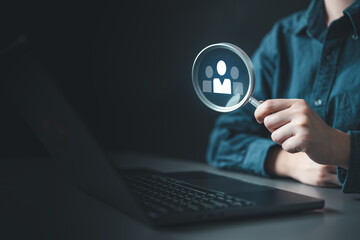 Human resources recruitment concept showing candidate search and talent selection using a magnifying glass on a laptop, representing hiring, evaluation, and strategic workforce management.