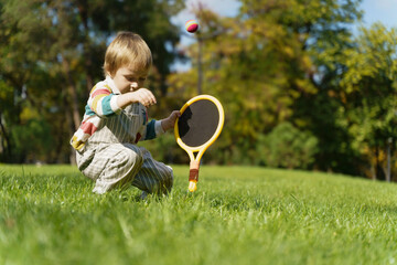 Toddler Child Playing Tennis with Racket in Sunny Park