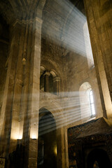 Light Beams Streaming Through Window in Ancient Stone Cathedral Interior