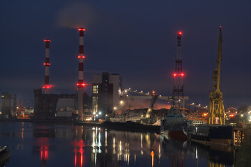 The combined heat and power plant at night, reflected in the water