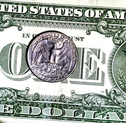 US quarter dollar coin on a one dollar bill, showing American money and currency background.