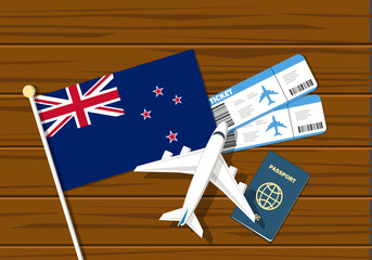 Flag off New Zealand with passport and toy airplane on wooden background. Flight travel concept
