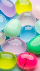 Colorful translucent jelly beans or candy on pastel colored background