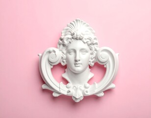 A classical plaster bust against a flat, soft pink backdrop. Intricate details of the woman's face and surrounding flourishes are visible